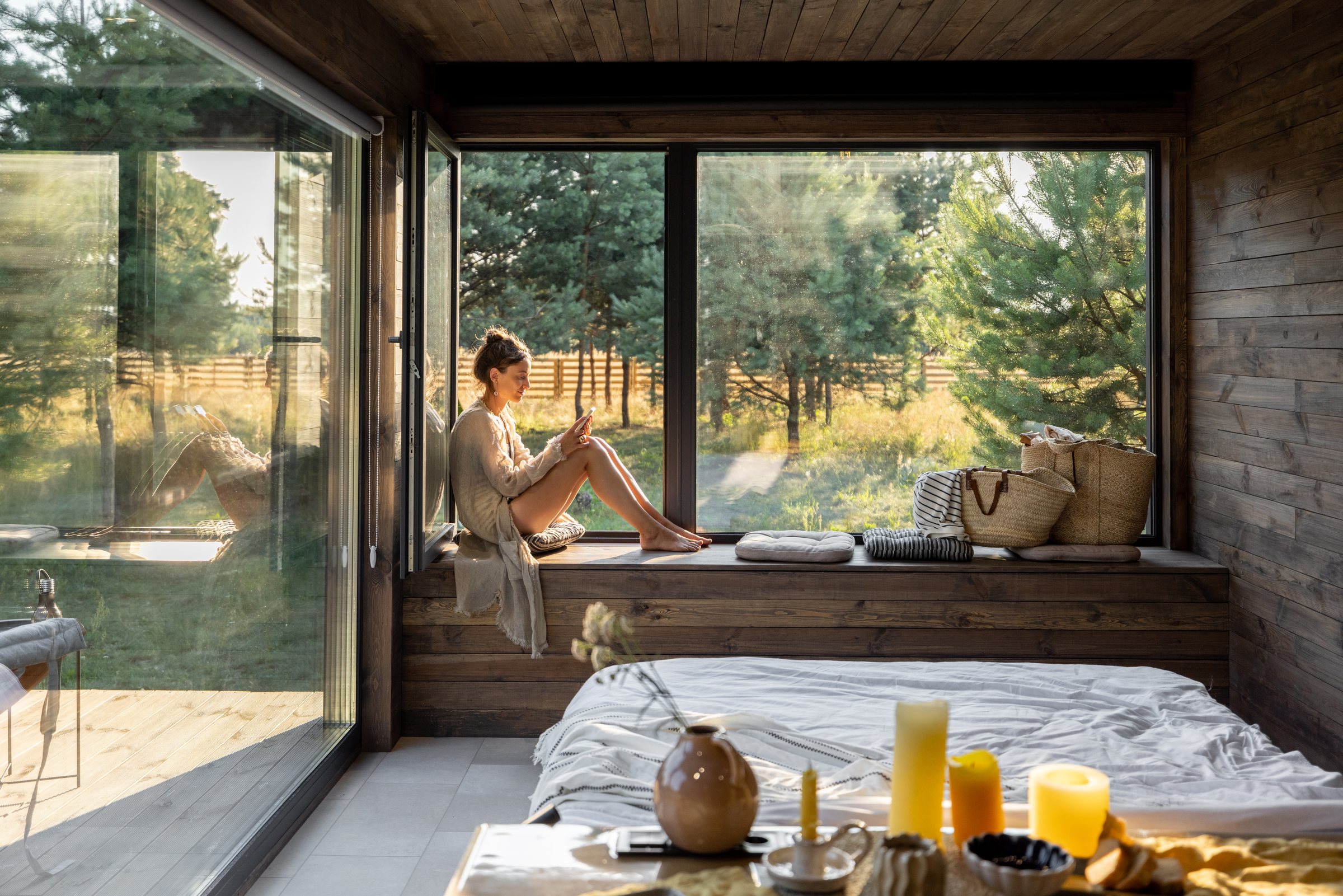 A restful cabin bedroom opening onto a pine forest